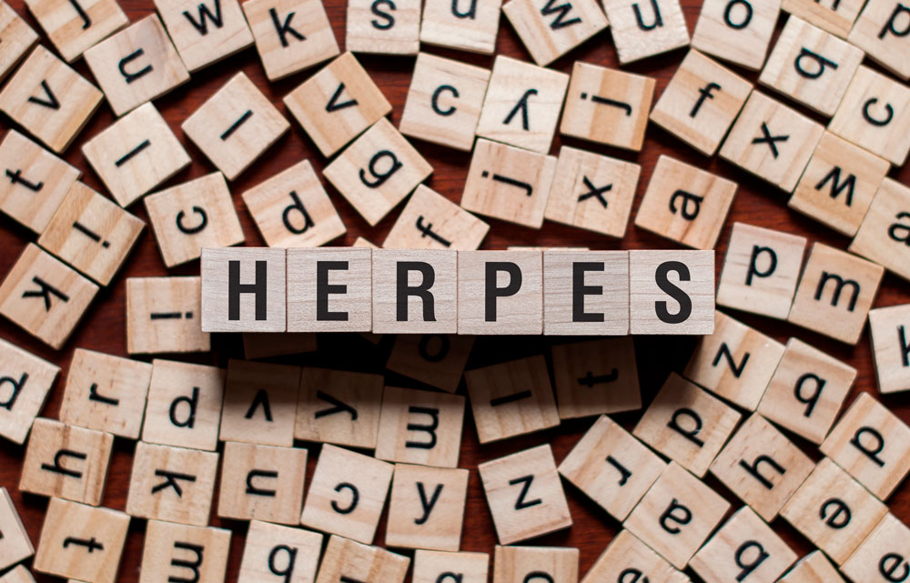 Buchstabenwürfel aus Holz mit dem Wort Herpes